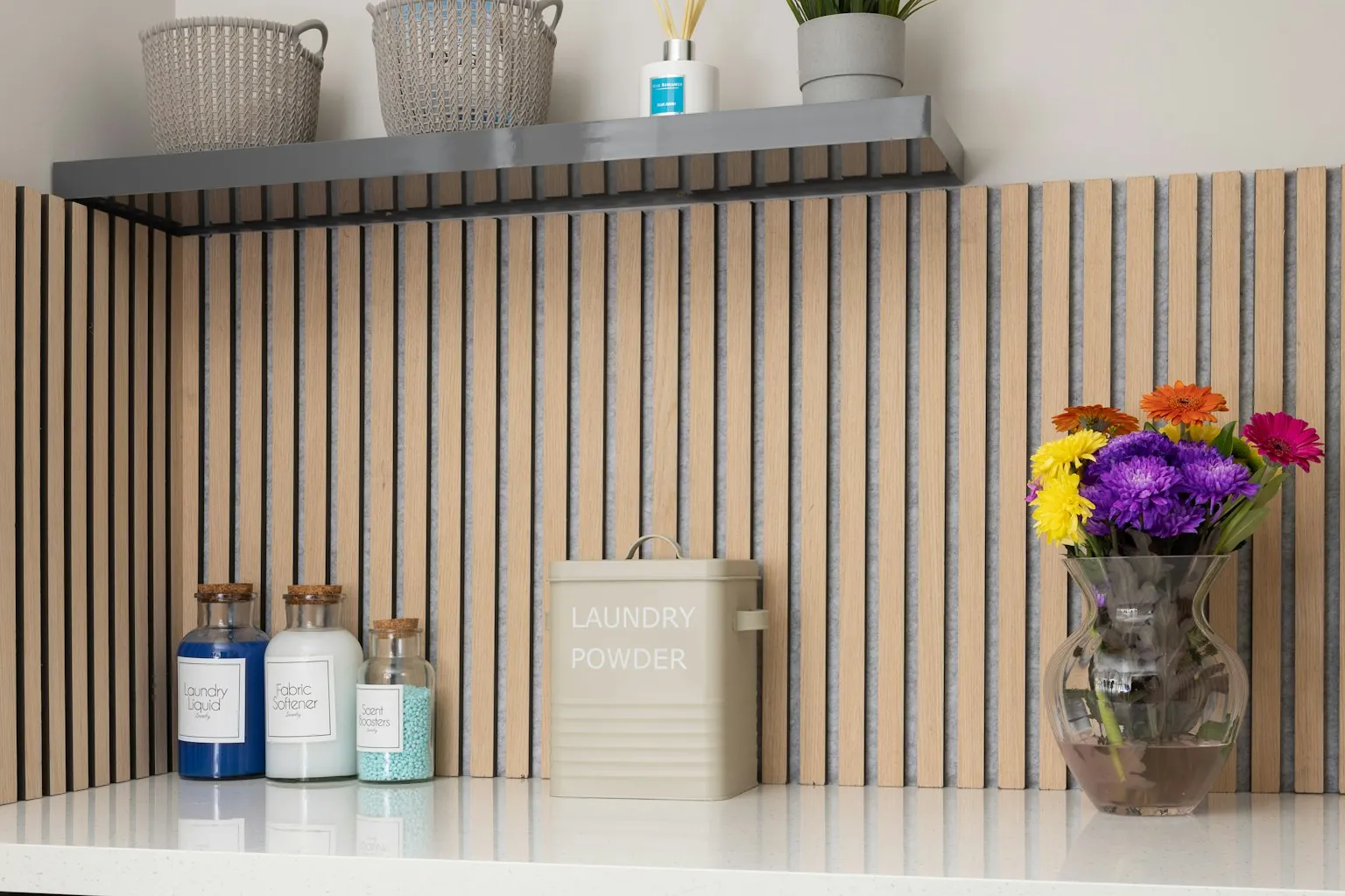 Plank met potten wasmiddel en een vaas bloemen