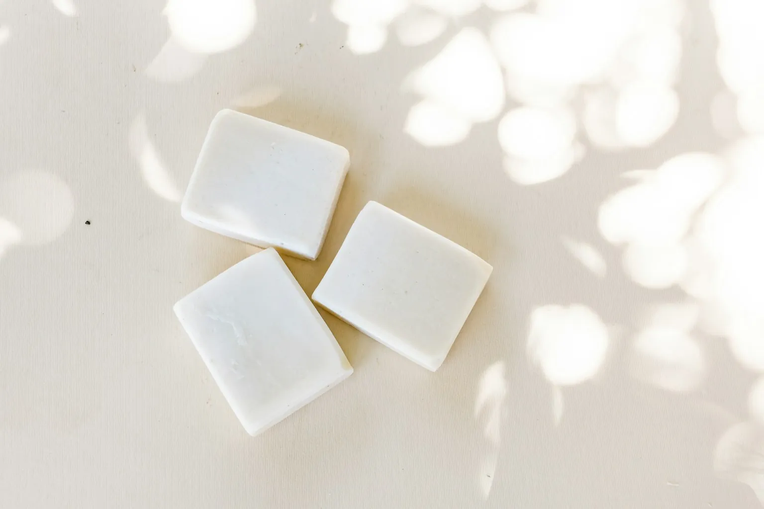 Drie witte blokjes zeep op een lichte ondergrond