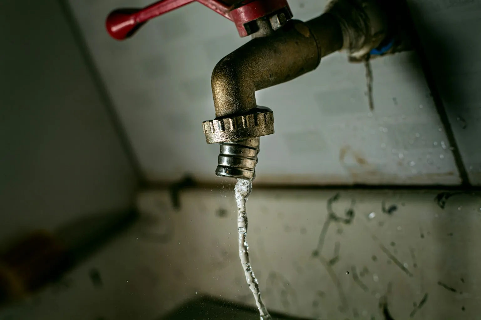 Water loopt uit de koppeling van een kraan
