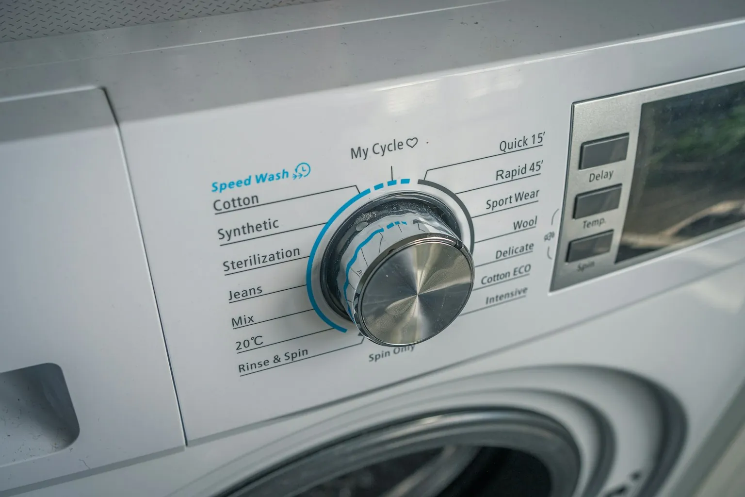 Programmaknop en centrifugeknop van een witte wasmachine